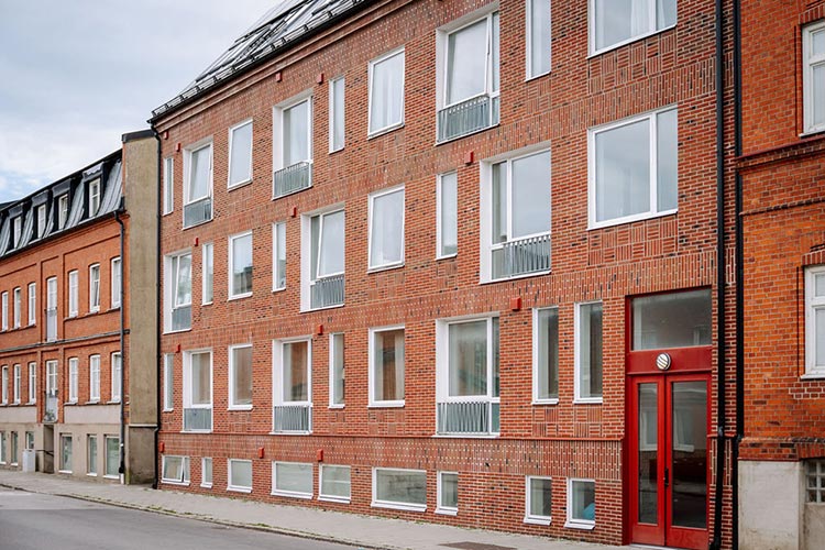 Ett stort tegelhus med en röd dörr.